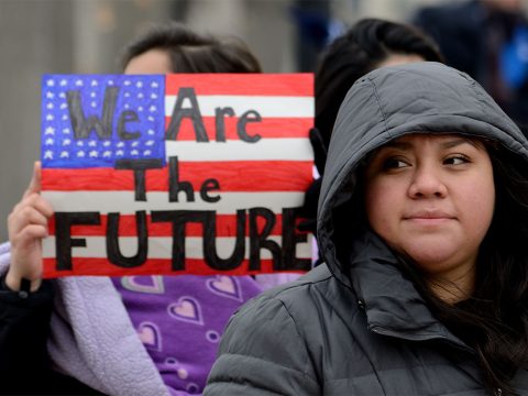 young hispanic woman in front of we are the future sign